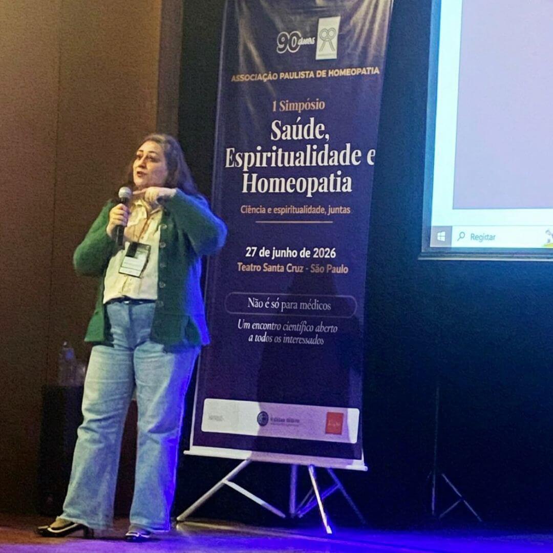 Dra. Juliane Piasseschi de Bernardin Gonçalves apresentando sua palestra no simpósio, com slide de etapas projetado ao fundo.